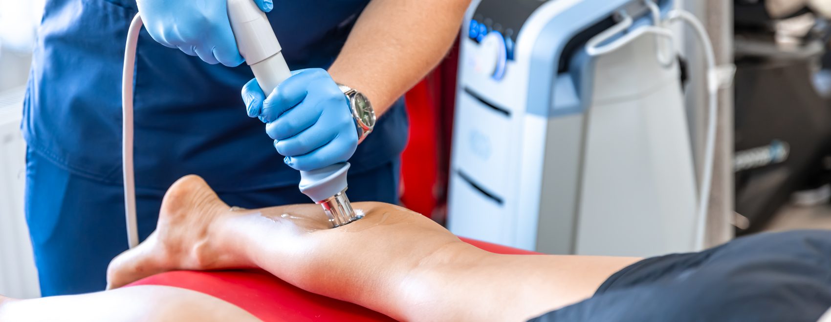 Shock wave therapy, the magnetic field, rehabilitation, physiotherapist doctor performs surgery on a patient's shin, mobility